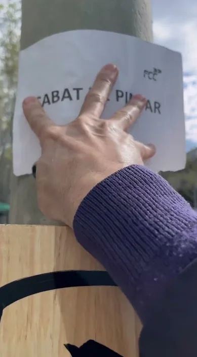 Hand placing a freshly painted sign in Catalan on a newly painted work, Barcelona, Art Is Trash
