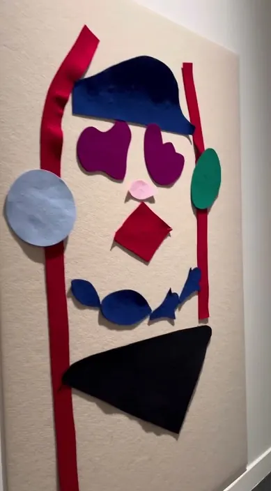 Face assembled from coloured pieces of fabric on a white board, Barcelona, Art Is Trash