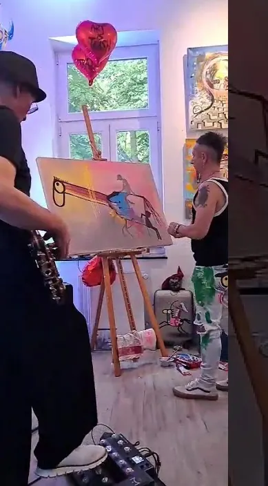 Painting on an easel beside a guitarist in a bright studio with heart balloons, Düsseldorf, Art Is Trash
