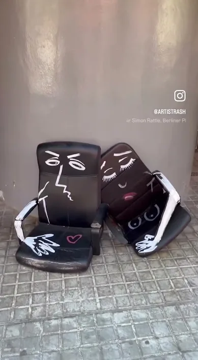 Two old armchairs painted with faces on the pavement, Barcelona, Art Is Trash