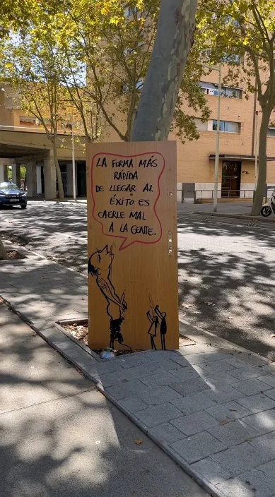 Wooden board with a saying about success, standing in the street, Barcelona, Art Is Trash