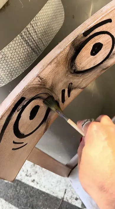 Curved wooden chair with painted eyes, Barcelona, Art Is Trash