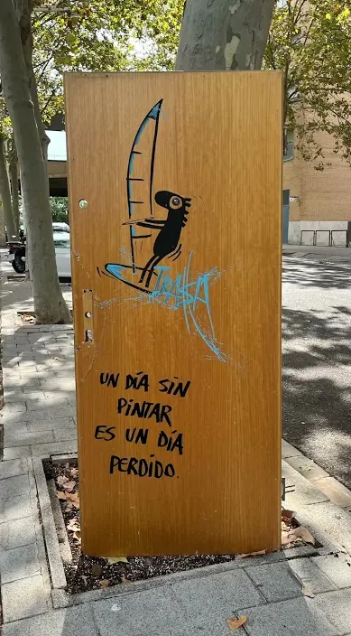 Wooden door painted with a figure and the line “a day without painting is a day lost”, Barcelona, Art Is Trash
